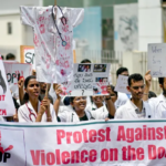 Doctors hold posters to protest the rape and murder of a young medic from Kolkata, at the Government General Hospital in Vijayawada on August 14, 2024