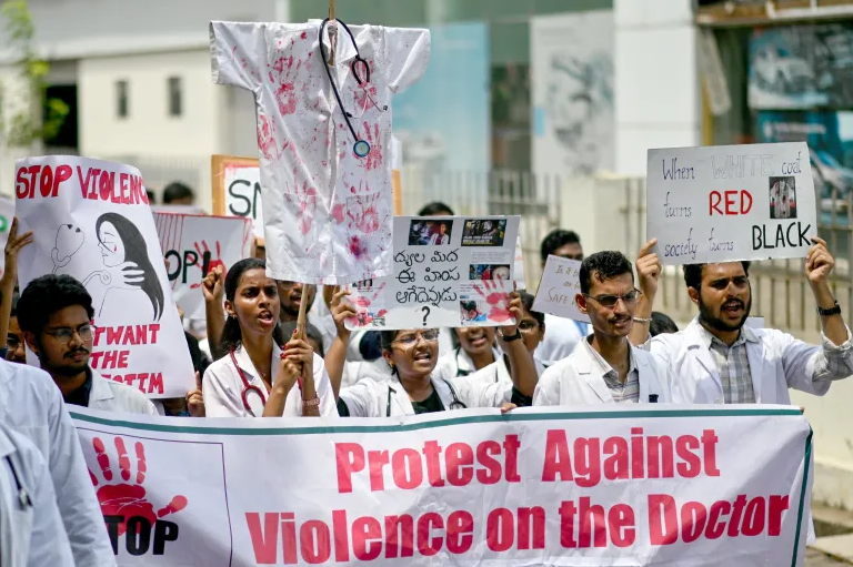 Doctors hold posters to protest the rape and murder of a young medic from Kolkata, at the Government General Hospital in Vijayawada on August 14, 2024